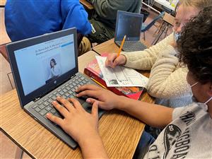 PHoto shows student researching on a laptop